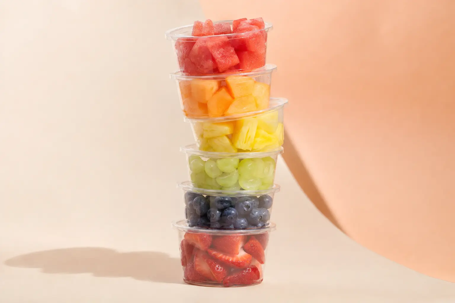 Six unbranded fruit cups stacked into a colour spectrum